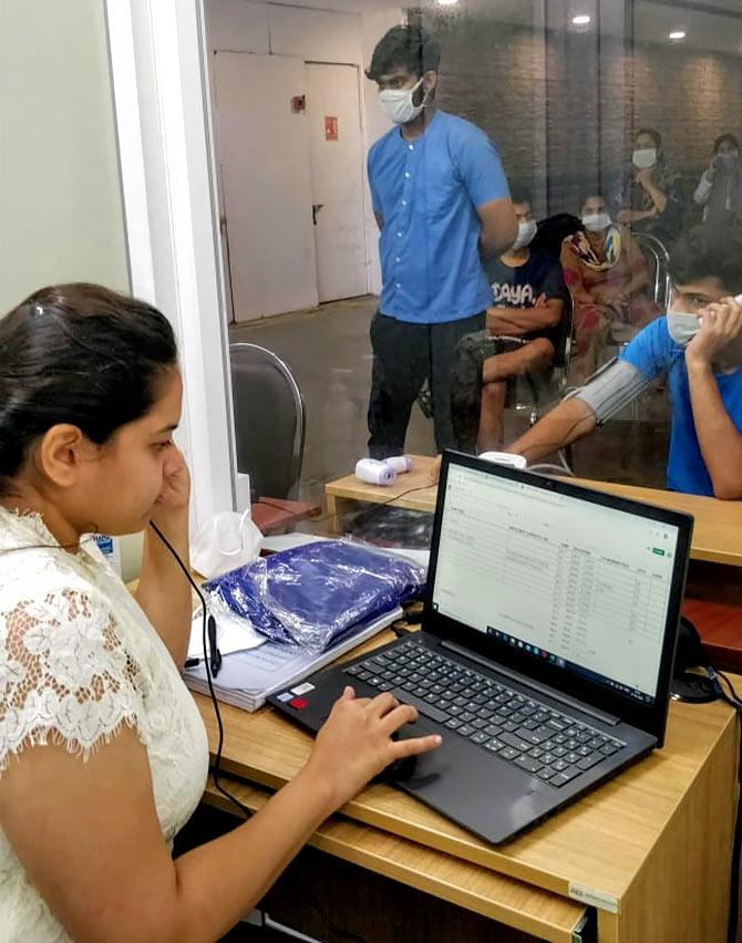 Dhruvi Shah during a consultation with a patient from the contact-less booth. Since consulting was from behind the glass interface, PPE suits were not required inside the cabin which had Hepa filter ACs that ensured air was changed quickly 