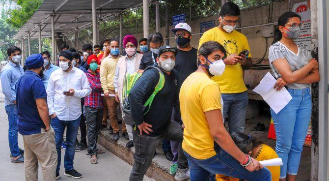 People queue for COVID-19 screening at the Ram Manohar Lohia hospital in New Delhi. Photograph: PTI Photo