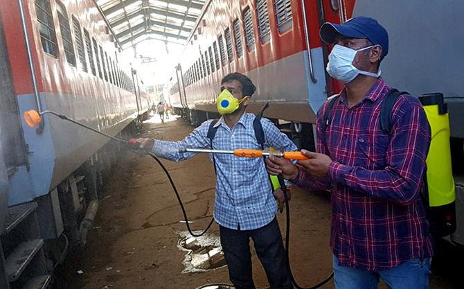 Workers spray disinfectants on a train coach, which will be used as isolation ward for treating coronavirus patients, in New Delhi, March 28, 2020. Photograph: PTI