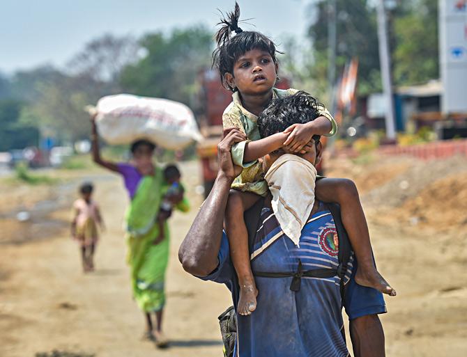 A migrant worker along with his family walks along the Mumbai-Ahmedabad highway, following the coronavirus lockdown, in Palghar, Maharashtra. Photograph: Mitesh Bhuvad/PTI Photo