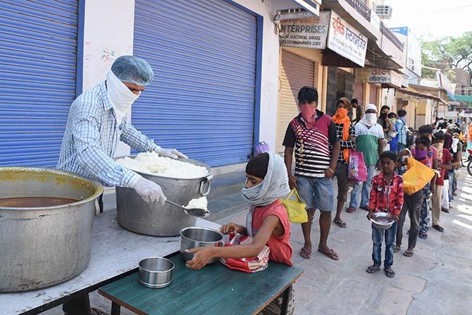 A volunteer serves food to the needy in Bikaner