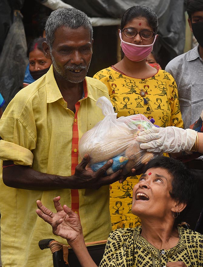 A visually challenged person in Kolkata receives a relief packet from volunteers during the ongoing COVID-19 lockdown.