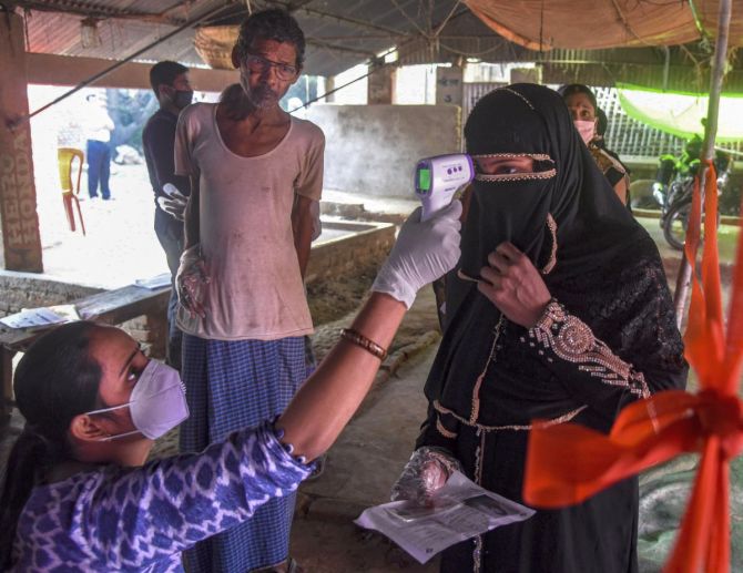 A voter undergoes thermal screening at a polling station in Bihar, October 28, 2020. Photograph: PTI Photo