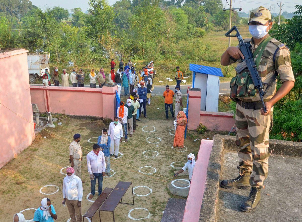 Voters, adhering to social distancing norms, stand in a queue to cast their votes for the first phase of the Bihar assembly election at Alipur block in Kaimur district, October 28, 2020. Photograph: PTI Photo