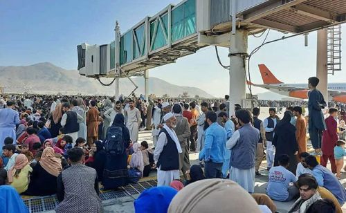 Afghans clamber on top of a plane at Kabul airport