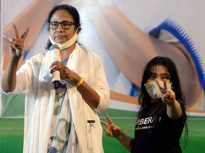 Trinamool Congress leader Mamata Banerjee and her grand niece Azania, her nephew Abhishek's daugher, flash the victory sign after the TMC's triumph in the Bengal assembly election, May 2, 2021. Photograph: Saikat Paul/ANI Photo