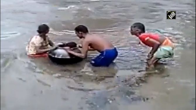 Children carried inside cooking pot on flooded Chhattisgarh river