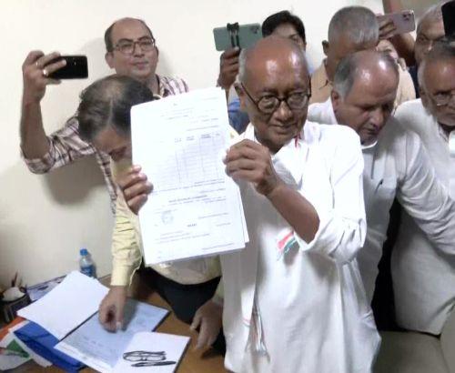 Digvijaya Singh holds up his nomination papers