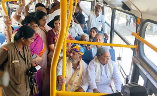 DK Shivakumar interacts with a conductor as he travels in a bus with CM Siddaramaiah