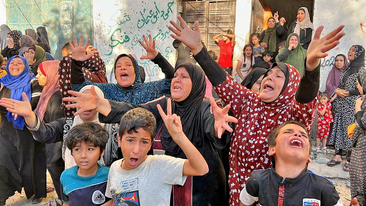 Palestinians react at the site of an Israeli strike on a house. Mutasem Murtaja/Reuters