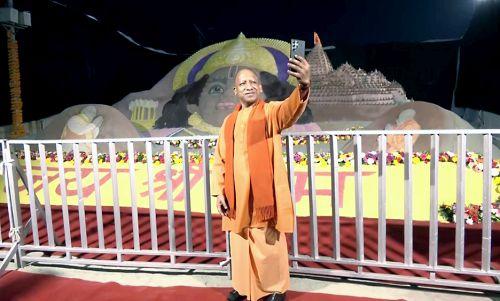 Yogi Adityanath takes a selfie with a sand art sculpture