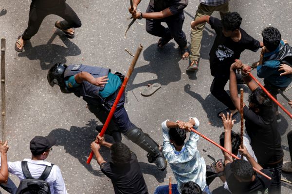 A mob beats a cop. Reuters/Mohammad Ponir Hossain.