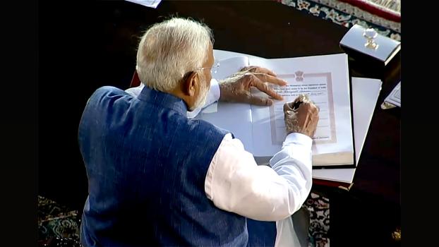 Narendra Modi signs the register after being sworn in as PM, June 9, 2024/ANI Photo