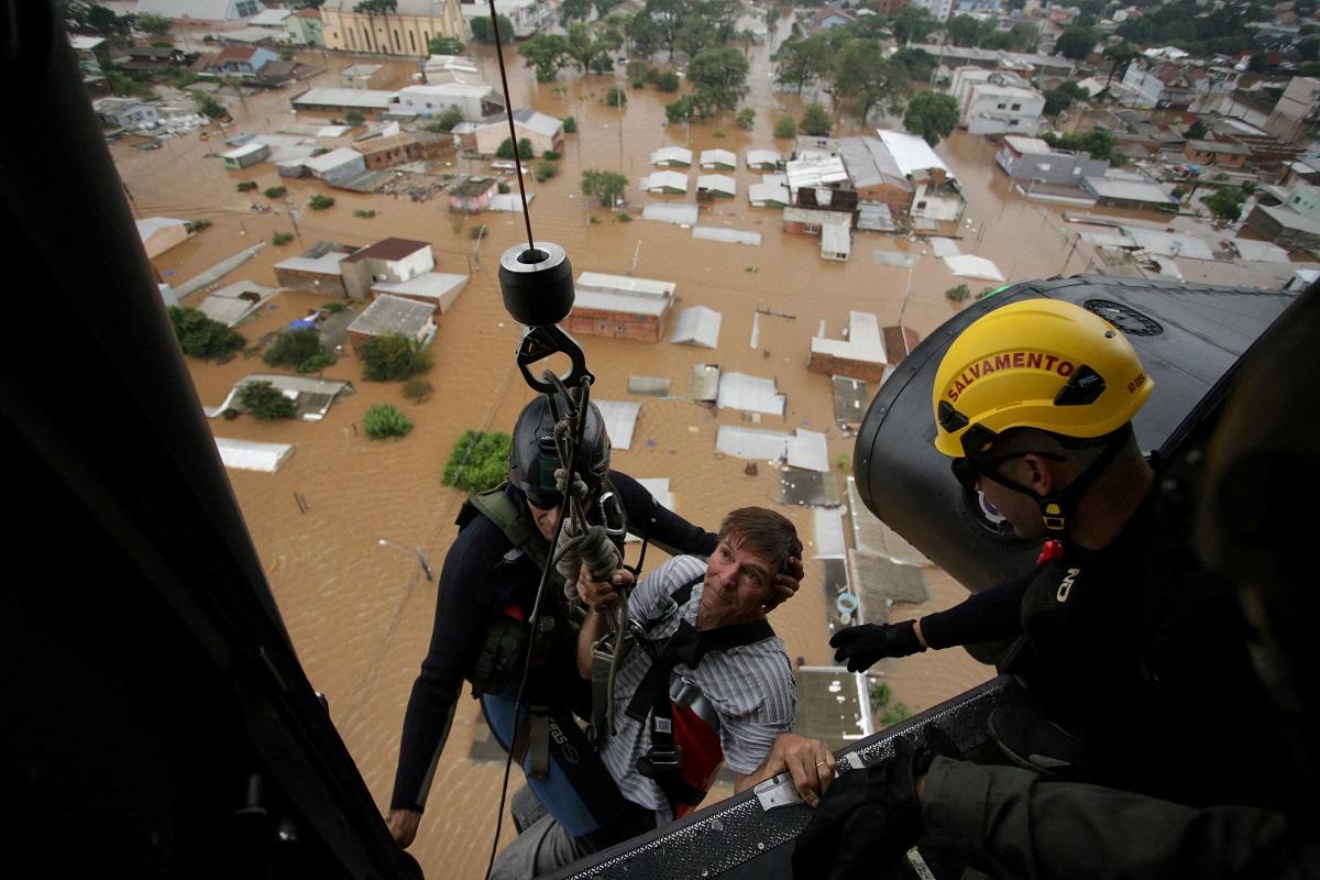 A man is rescued after the floods in Canoas, Brazil, May 4, 2024/Renan Mattos/Reuters