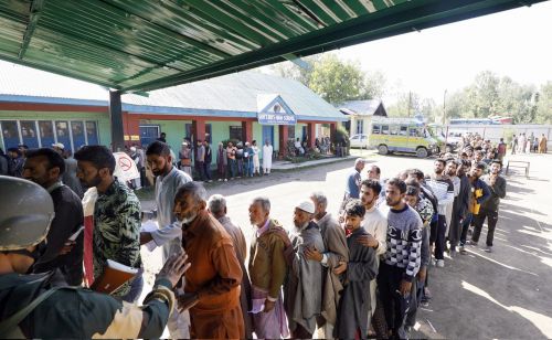 People wait in a queue to vote in Baramulla