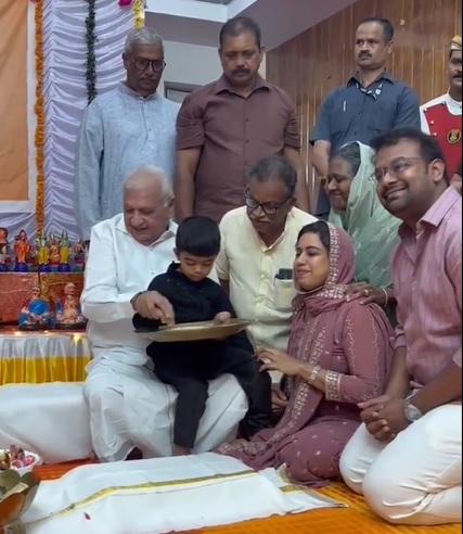 Kerala Governor Arif Mohammed Khan Initiating a boy into writing his first letter at the Vidyarambham ceremony held at Raj Bhavan/Courtesy Kerala Governor on X