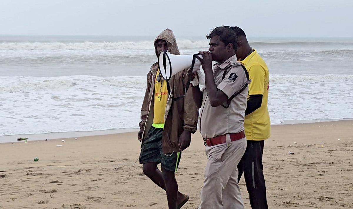 A policemen asks people to evacuate from Puri