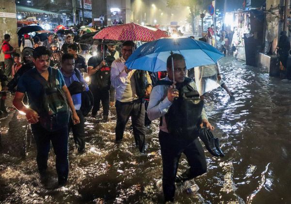 Harrowed commuters wade through a road in Ghatkopar