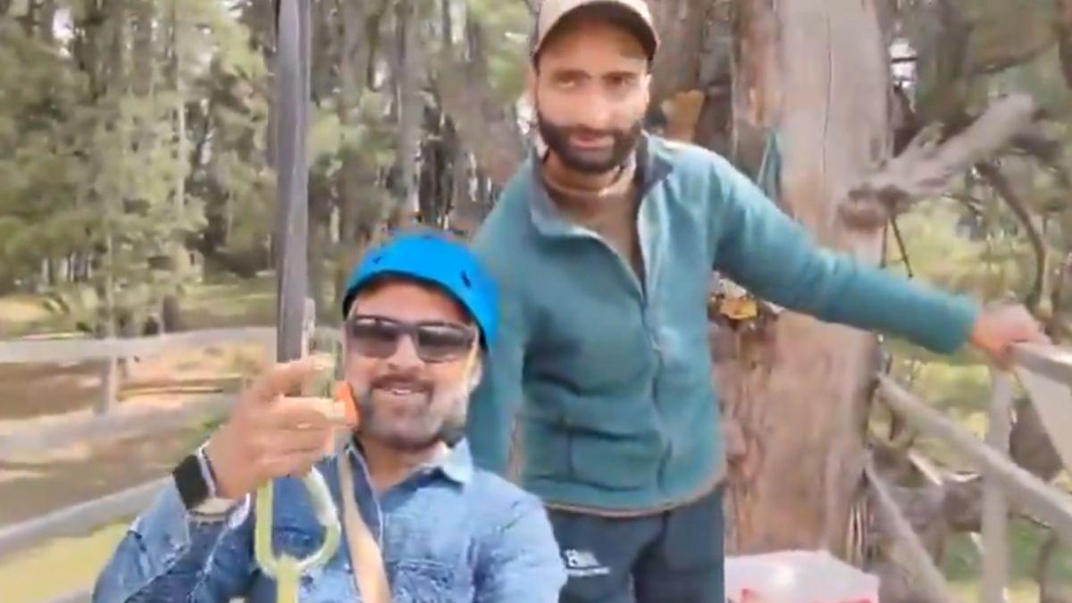 Tourist Rishi Bhatt with the zip line operator behind him