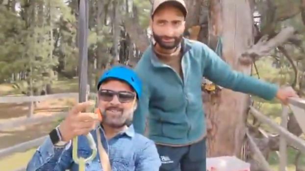 Tourist Rishi Bhatt with the zip line operator behind him