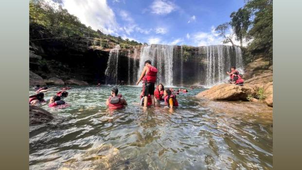 Tourists swim in the waters of Krang Suri Waterfall in Meghalaya