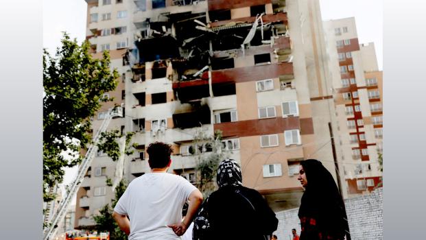 IMAGE: People look at a damaged building in Tehran. Photograph: Majid Asgaripour/WANA/Reuters