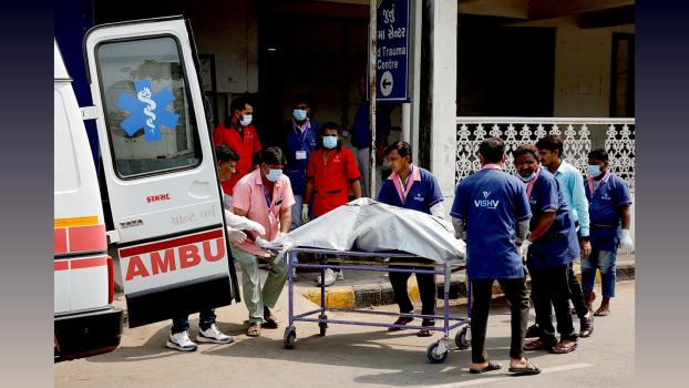 Health workers shift the body of a victim