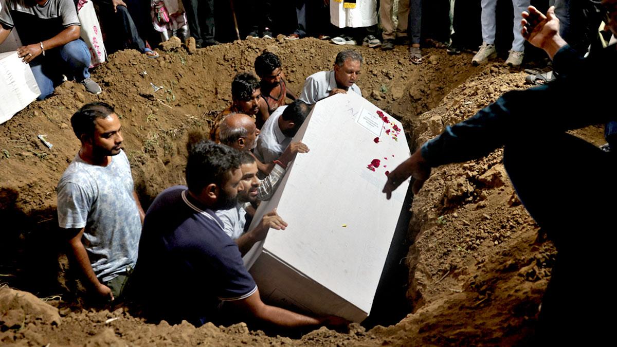 The coffin containing the remains of a victim are put to rest