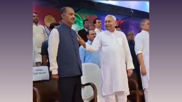 Nitish Kumar grabbed the officer next to him and was seen to be talking and smiling