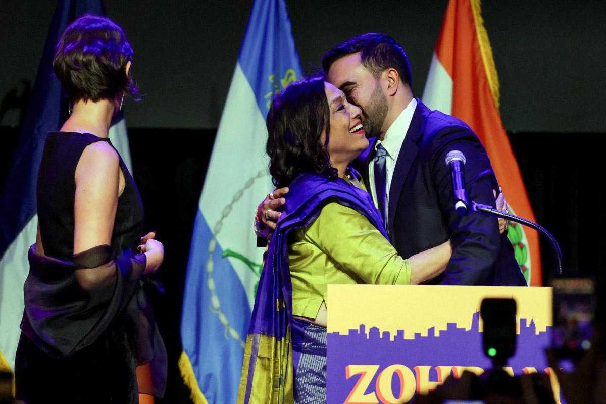 Zohran Mamdani kisses his mother Mira Nair as his wife Rama Duwaji stands by. Pic: Jeenah Moon/Reuters