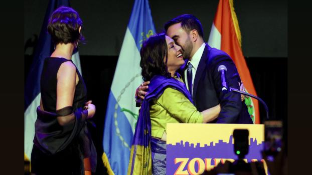 Zohran Mamdani kisses his mother Mira Nair as his wife Rama Duwaji stands by. Pic: Jeenah Moon/Reuters