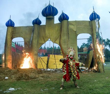 A devotee dressed as Lord Hanuman stands as an effigy of Ravana burns during Ravan Dahan at Parade Ground A devotee dressed as Lord Hanuman stands as an effigy of Ravana burns during Ravan Dahan at Parade Ground