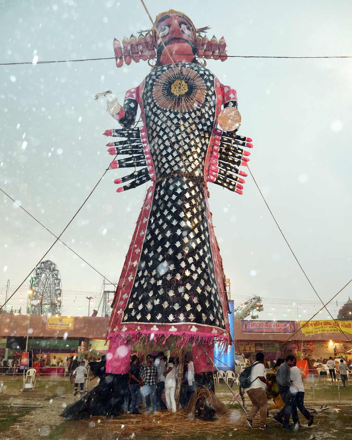 人們在拉萬達漢（Ravan Dahan）期間在納維爾·達米克·拉姆勒拉拉（Nav Darmik Ramlelala）的大雨中避難