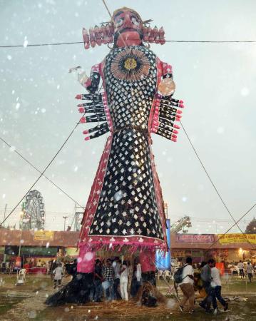 People take shelter under Ravan effigy during Ravan Dahan amid heavy rainfall at Nav Dharmik Ramleela People take shelter under Ravan effigy during Ravan Dahan amid heavy rainfall at Nav Dharmik Ramleela
