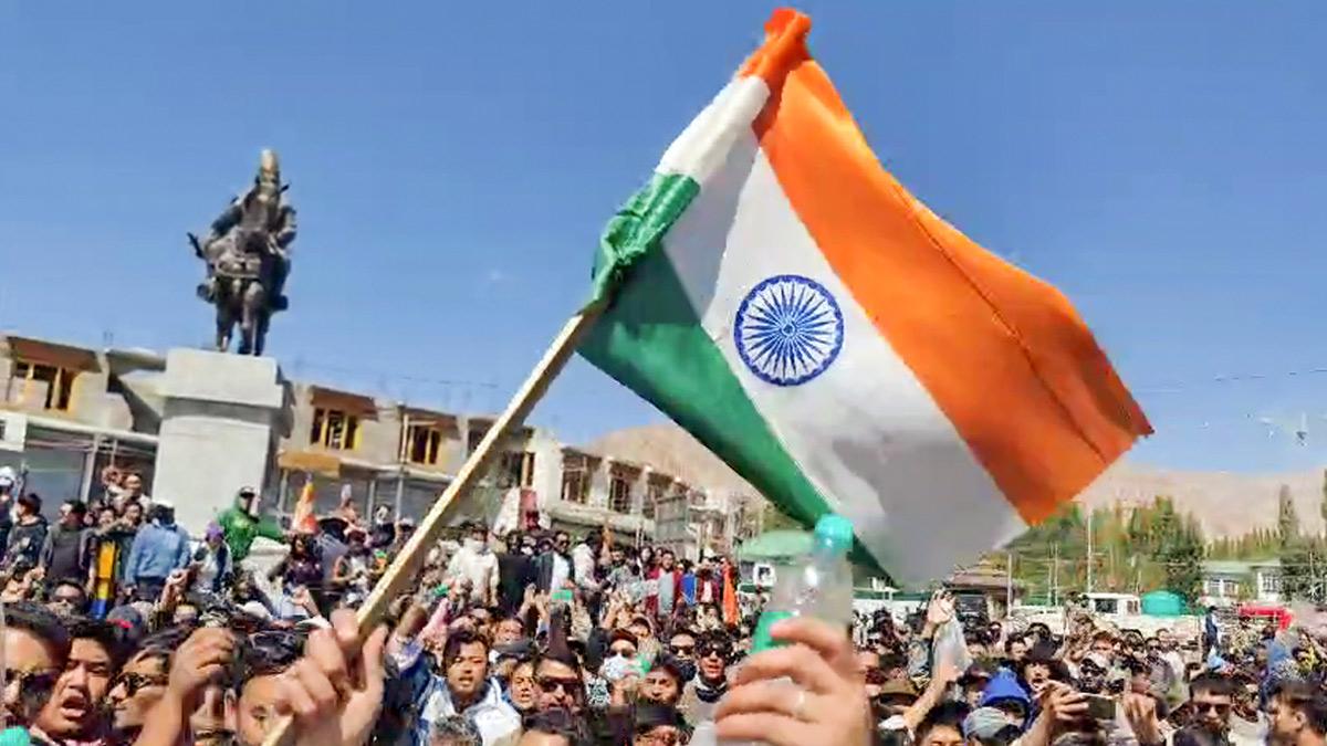 A protestor holds an Indian national Flag during a massive protest over the statehood demand and the inclusion of Ladakh under the Sixth Schedule