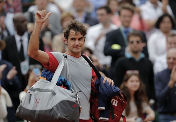 Roger Federer of Switzerland waves to the crowd as he leaves the court following his defeat 