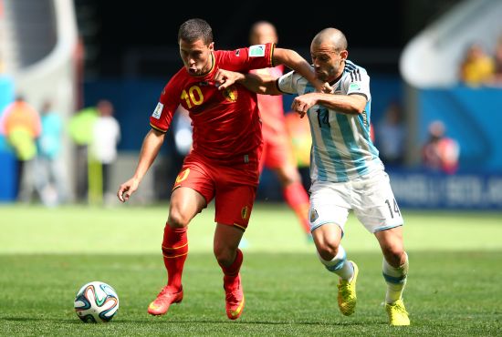 Eden Hazard of Belgium holds off the challenge of Javier Mascherano of Argentina