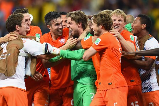 Goalkeeper Tim Krul of the Netherlands celebrates with teammates after making a save in a penalty shootout to defeat Costa Rica 