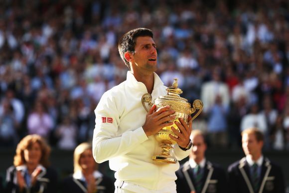 Novak Djokovic of Serbia poses with the Gentlemen's Singles Trophy following his victory against Roger Federer