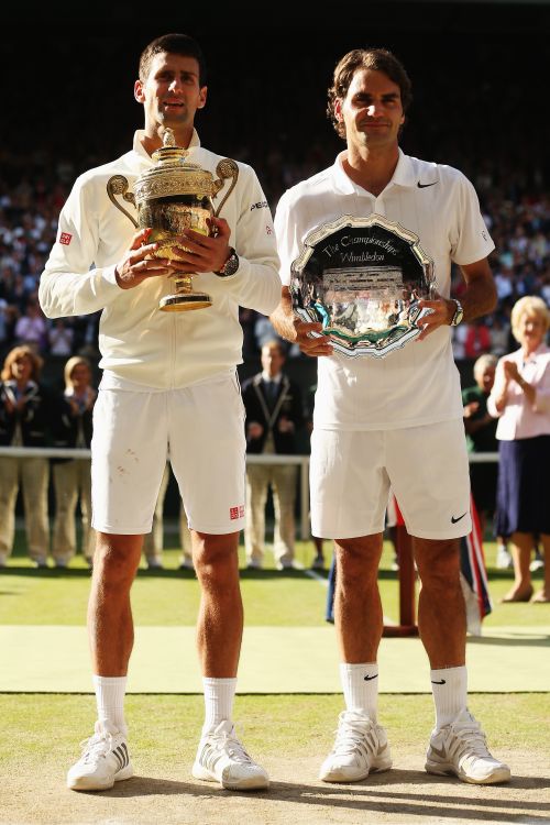 Novak Djokovic of Serbia poses with the Gentlemen's Singles Trophy next to Roger Federer of Switzerland 