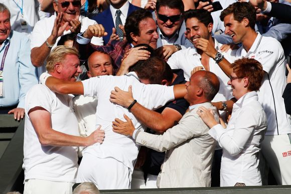 Novak Djokovic of Serbia celebrates in his player's box with friends, family and coach Boris Becker