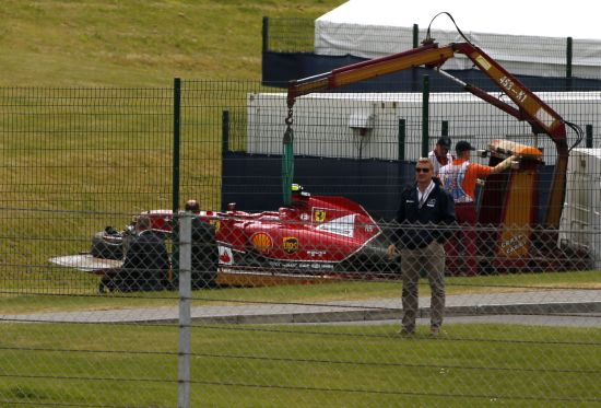 The car of Ferrari Formula One driver Kimi Raikkonen of Finland is lifted off the track following a crash 
