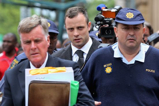 Oscar Pistorius (C) leaves North Gauteng High Court during a break on the third day of his trial accused of the murder of his girlfriend Reeva Steenkamp