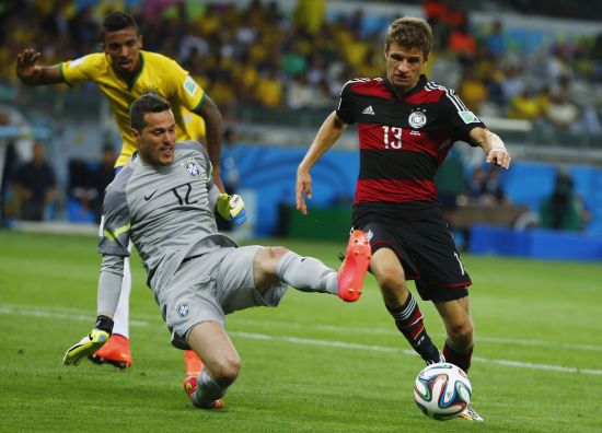 Brazil's goalkeeper Julio Cesar (L) fights for the ball with Germany's Thomas Mueller