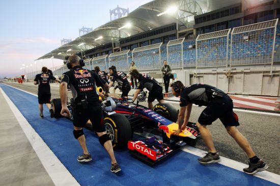 The car driven by Sebastian Vettel of Germany and Infiniti Red Bull Racing suffers a fault and is pushed back along the pitlane by team mates