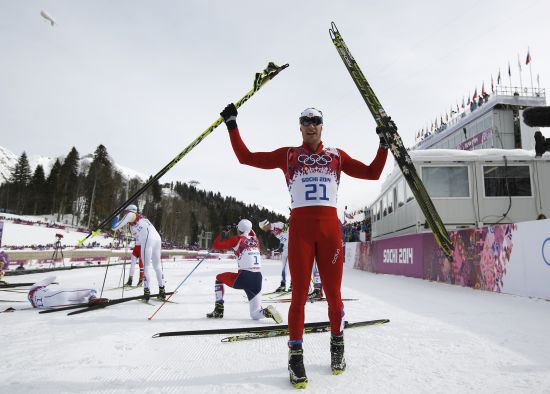 Dario Cologna celebrates after winning men's skiathlon