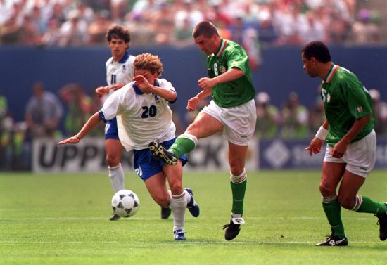 Roy Keane of Ireland kicks the ball as Giuseppe Signori of Italy tries to break it up