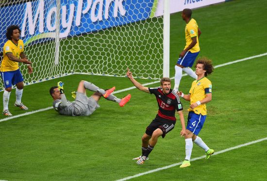 Thomas Mueller of Germany celebrates scoring his team's first goal past Julio Cesar of Brazil 
