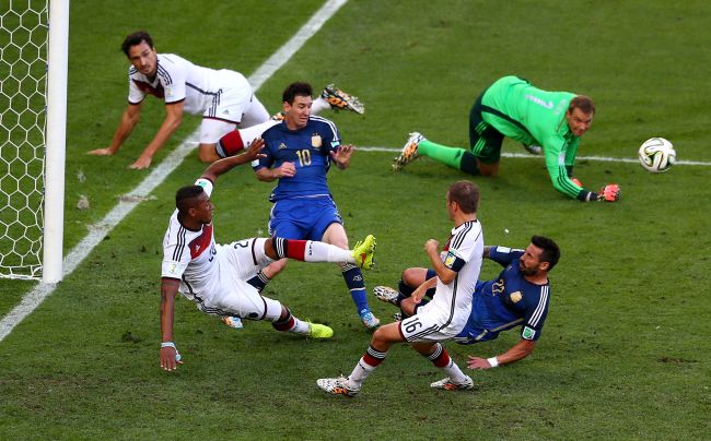 Lionel Messi and Ezequiel Lavezzi of Argentina attempt to shoot as Jerome Boateng of Germany clears the ball off the line