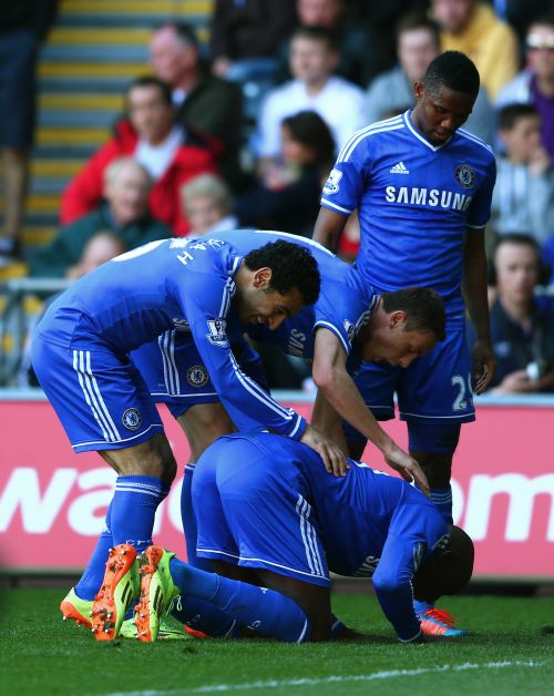 Demba Ba (ground) of Chelsea is congratulated by teammates after scoring the opening goal 